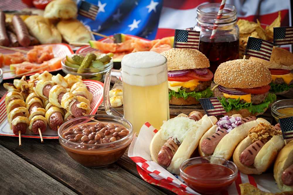 Image of traditional American foods, hot dogs, burgers, beer, etc.