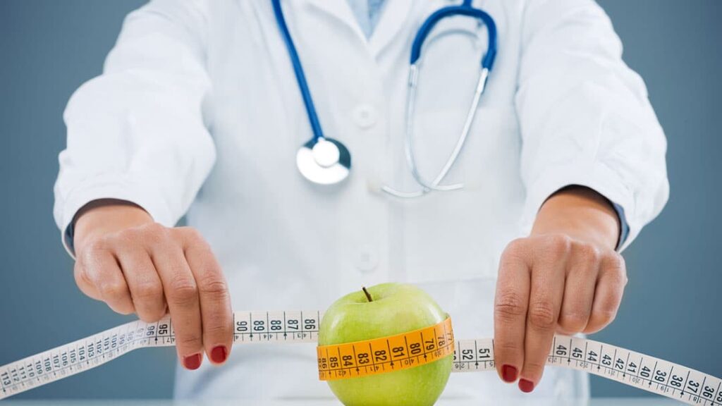 Image of a weight loss doctor measuring an apple.